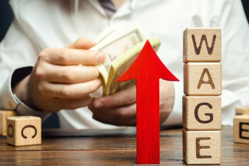 Wage spelled with blocks plus up arrow