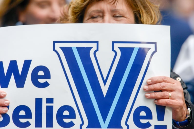 Woman holding Villanova We Believe sign