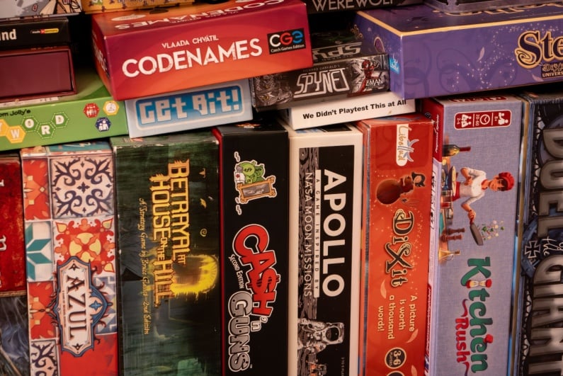 Board games crammed on a shelf