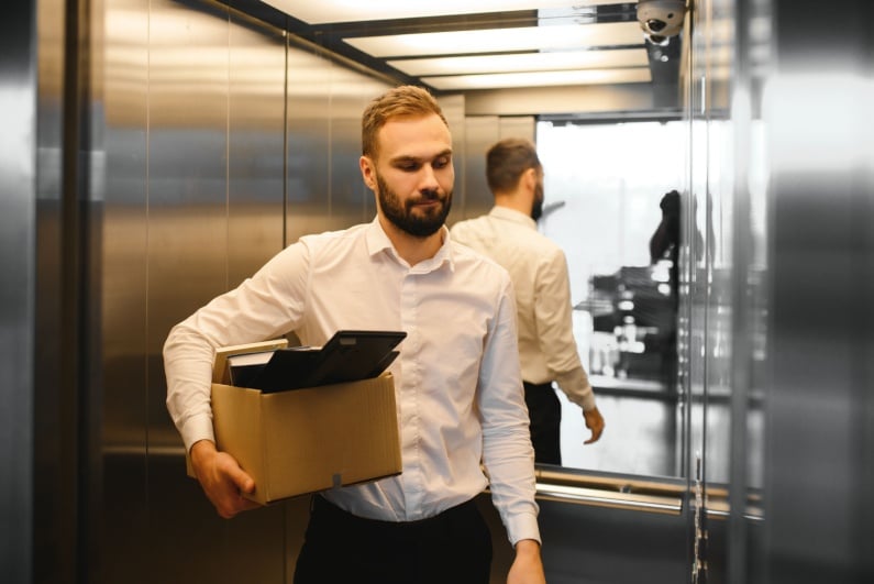 Man leaving office with belongings in box
