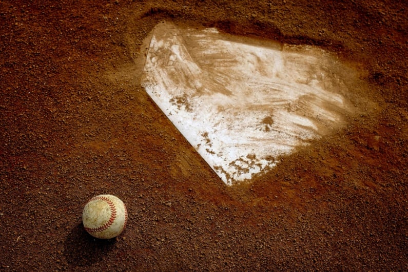 Baseball in the dirt next to home plate