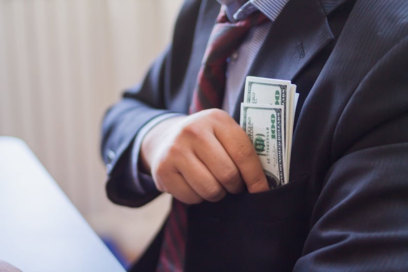 Businessman pocketing cash