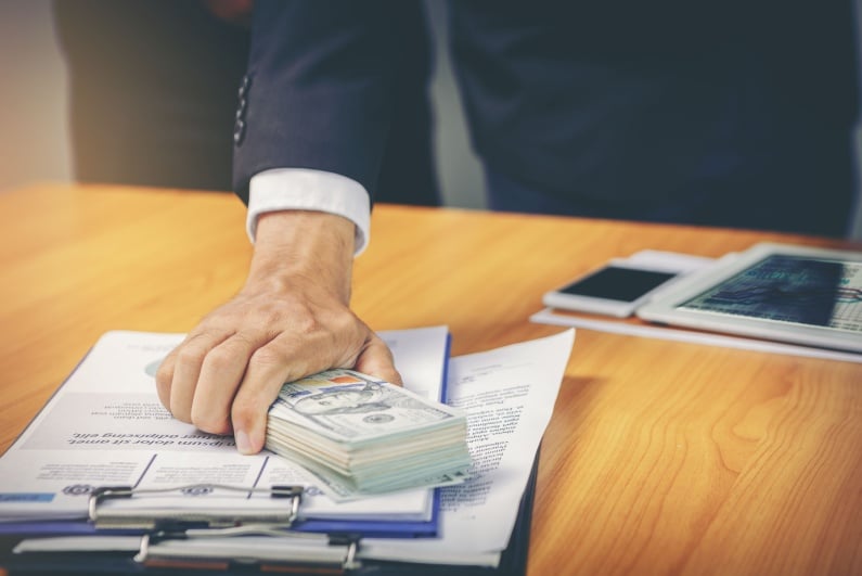 Person putting money on desk