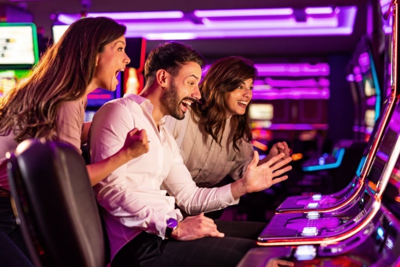 Man and two women celebrating slots win