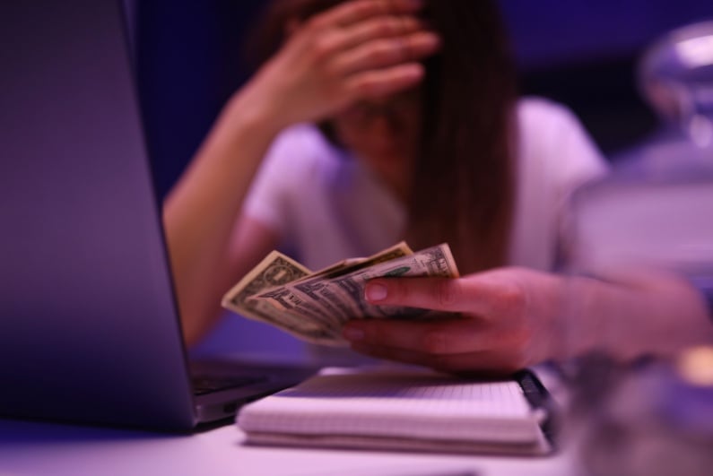 Woman looking sad with money