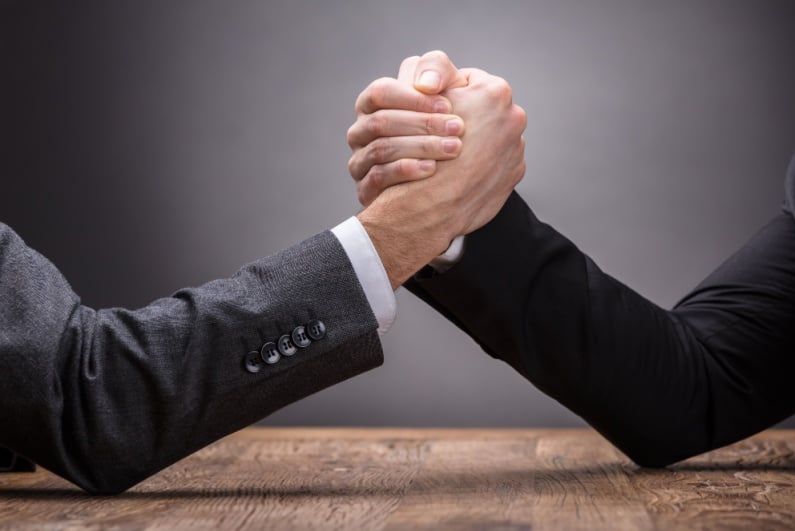 Businessmen arm wrestling