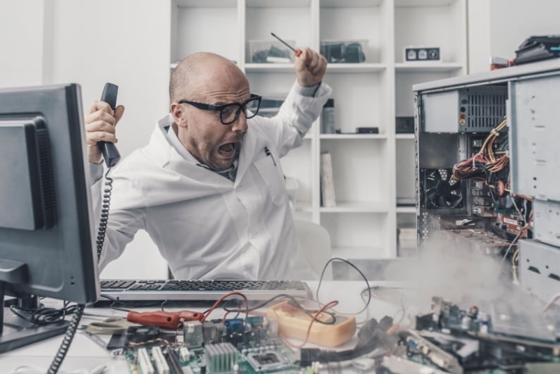 Panicked man trying to fix smoking computer