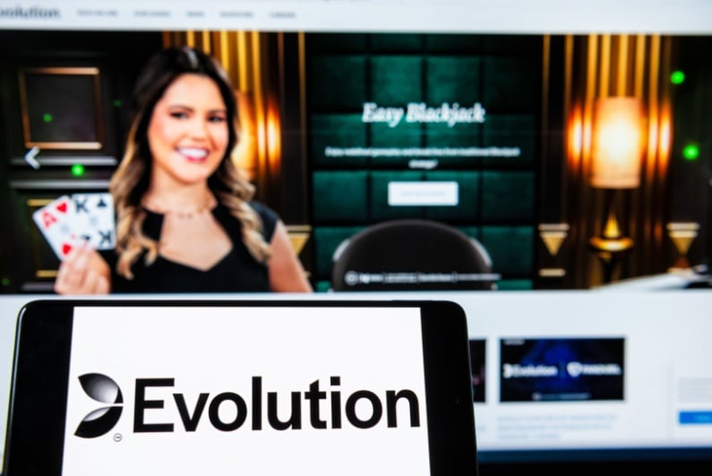 Evolution logo on phone with live dealer in background