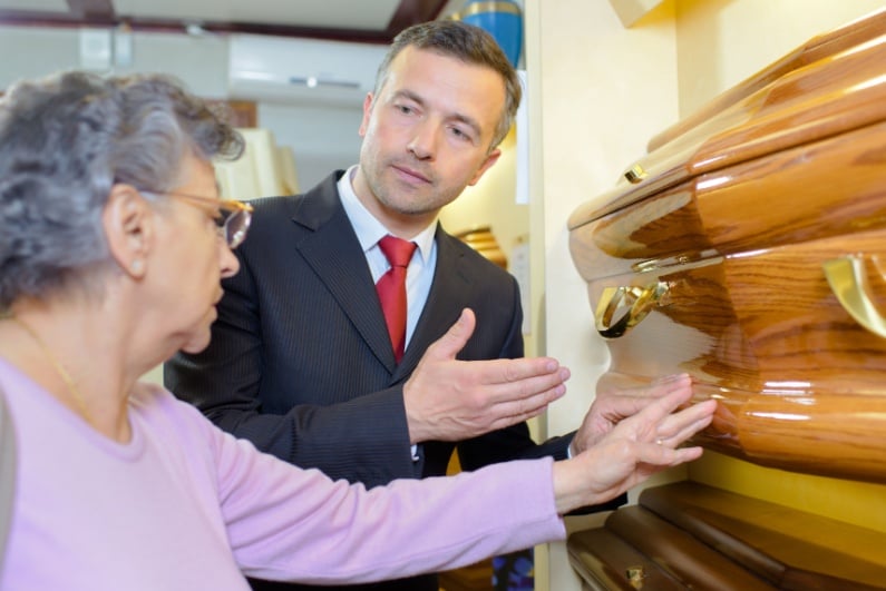 Funeral director showing woman a casket