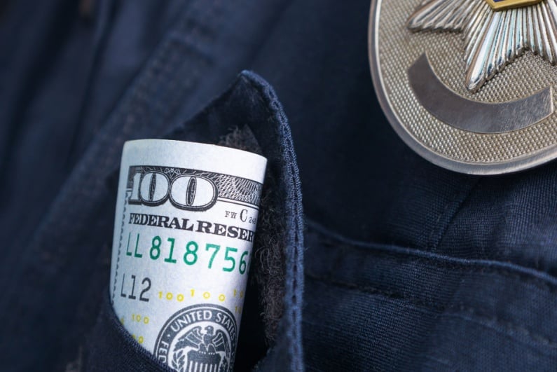 Cash in police officer shirt pocket
