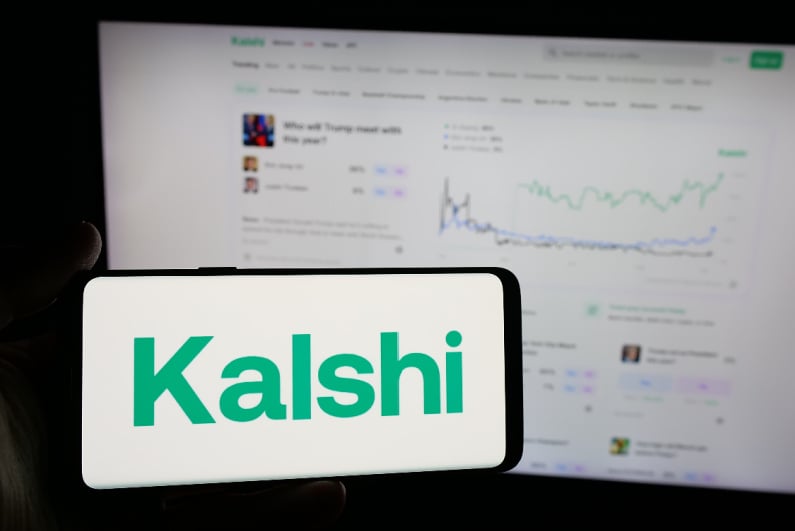 Kalshi logo on phone with website in background