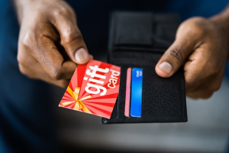 Man taking gift card out of wallet