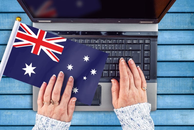 Woman at laptop with Australian flag