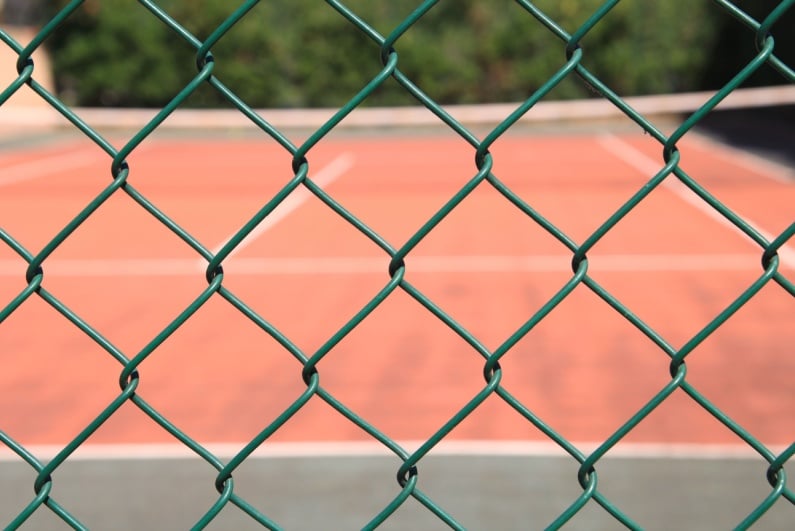 Tennis court behind fence