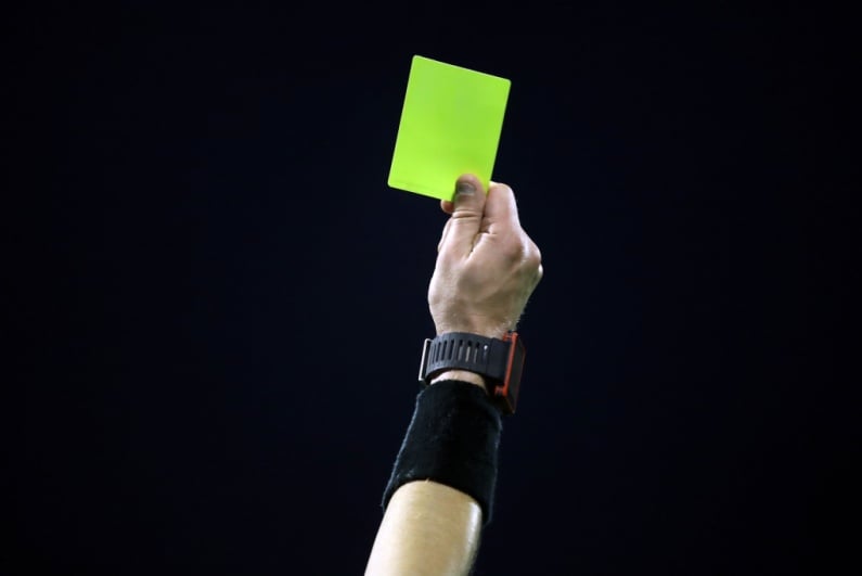 Soccer ref raising yellow card