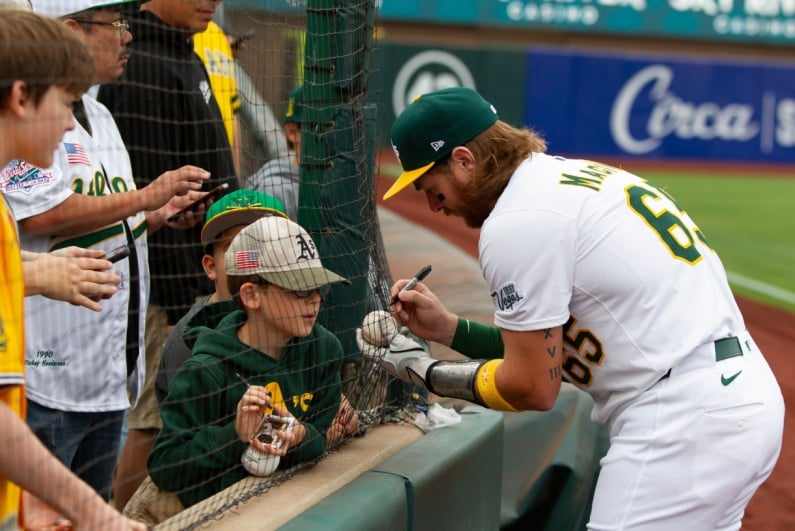 A's player signing autographs
