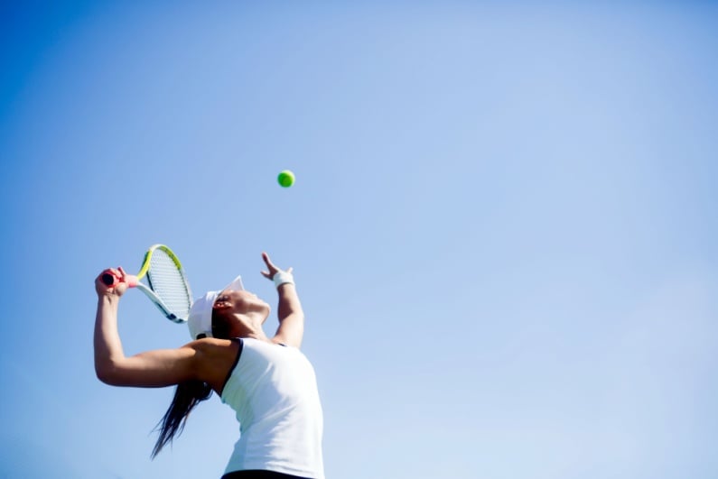 Female tennis player beginning serve