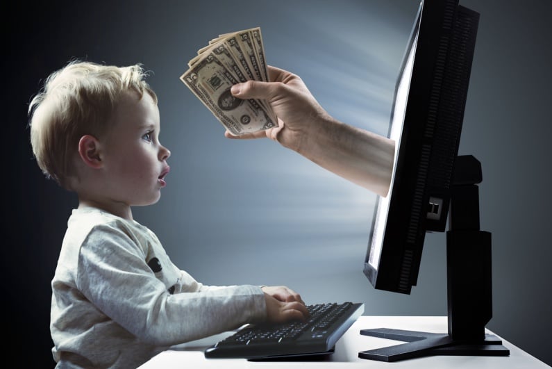 Little boy on computer with arm offering money through monitor