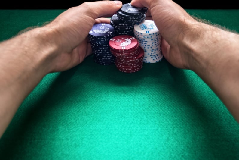 Man pulling in stacks of poker chips