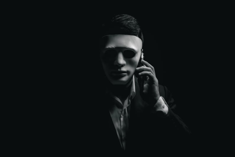 Masked man making phone call