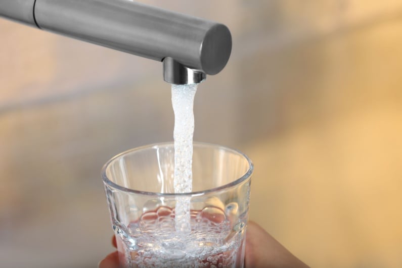 Person filling glass of tap water