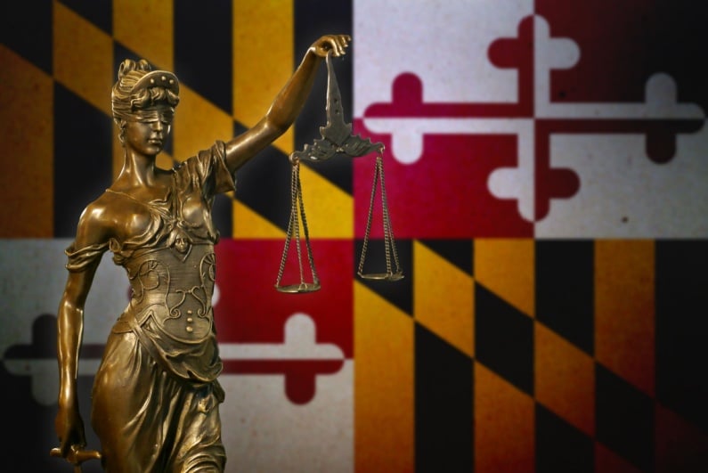 Lady Justice against a Maryland flag