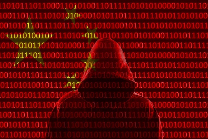 Hooded hacker in front of Chinese flag composed of binary digits