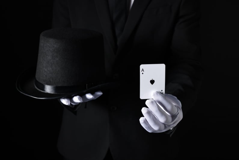 Magician holding top hat and ace of spades