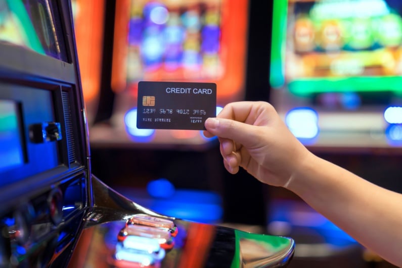 Person holding credit card at slot machine