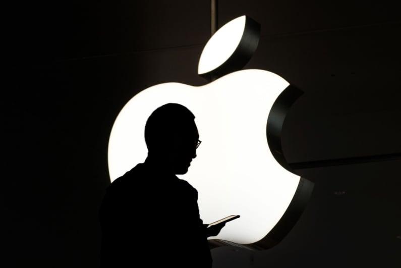Silhouette of man in front of Apple logo