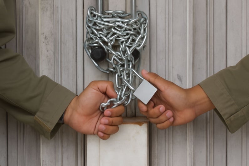 Two hands chaining door closed