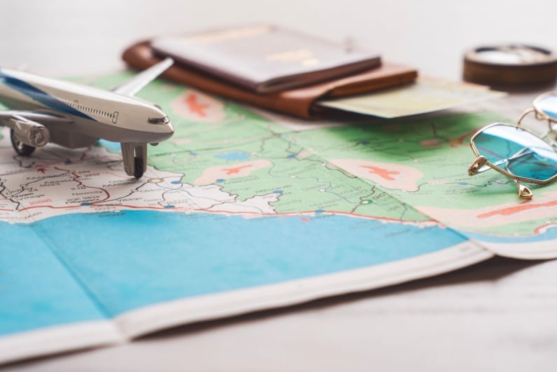 Toy airplane passport glasses compass on map