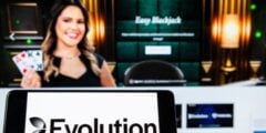 Evolution logo on phone with live dealer in background