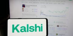 Kalshi logo on phone with website in background