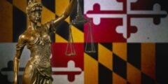 Lady Justice against a Maryland flag