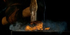 Blacksmith hitting anvil with hammer